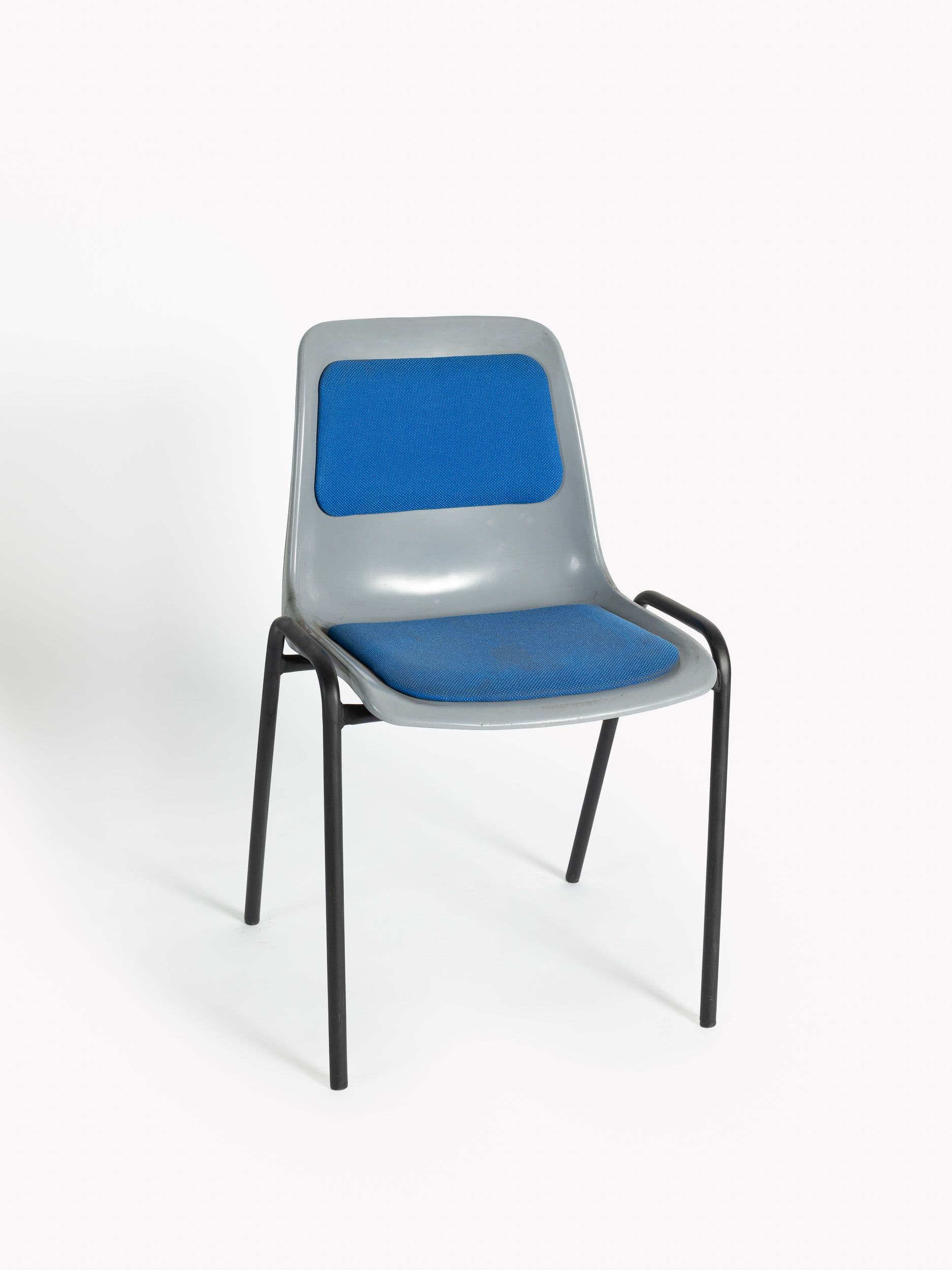 Stackable plastic chair upholstered in blue